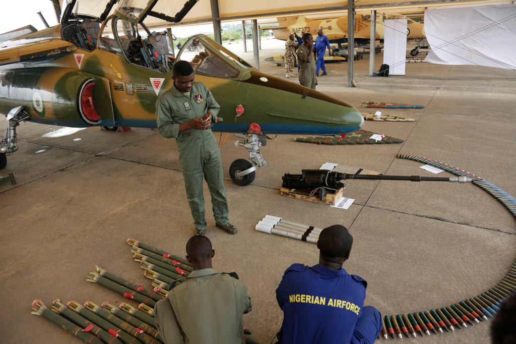FILE - In this photo taken on April 22, 2017, Nigerian Air Force officers display ammunition next to a fighter jet during an event in Makurdi, Nigeria. (AP Photo/ Sunday Alamba, file)