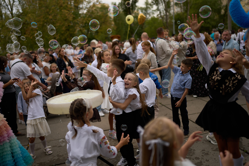 Children play with soap bubbles during the traditional back to school celebrations in Kyiv, Tuesday, Sept. 1, 2026. (AP Photo/Francisco Seco)