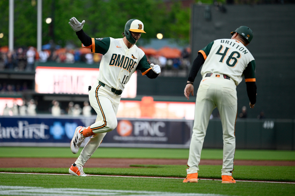 Baltimore Orioles' Dylan Beavers, left, celebrates after his home run with third base coach Buck Britton (46) as he rounds the bases during the first inning of a baseball game against the Boston Red Sox, Friday, April 24, 2026, in Baltimore. (AP Photo/Nick Wass)