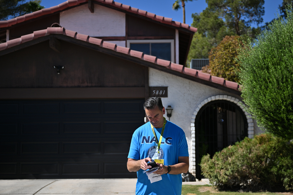 Paul Peterman of National Association of Letter Carriers checks his notes as he canvasses on Saturday, Sept. 12, 2026, in Las Vegas. (AP Photo/David Becker)