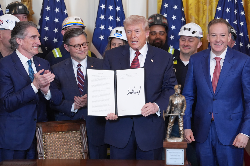 FILE - President Donald Trump holds an executive order regarding coal during an event in the East Room of the White House, Wednesday, Feb. 11, 2026, in Washington, as Interior Secretary Doug Burgum, House Speaker Mike Johnson of La., Environmental Protection Agency director Lee Zeldin and coal miners watch. (AP Photo/Evan Vucci, file)