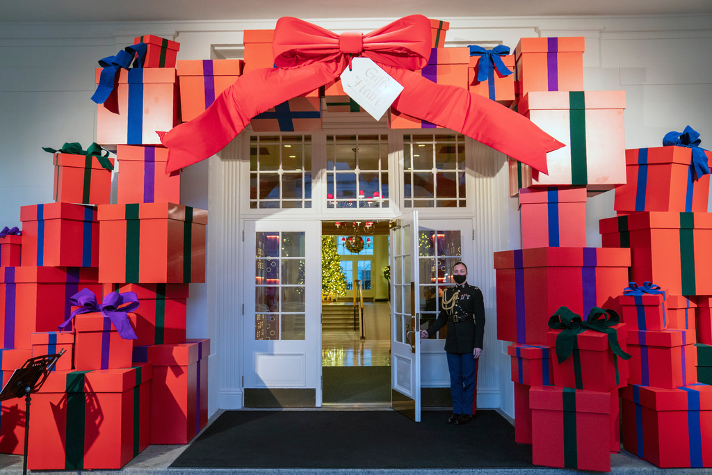 FILE - A Marine White House military social aide holds the door to the East Wing entrance of the White House during a press preview of the White House holiday decorations, Nov. 29, 2021, in Washington. (AP Photo/Evan Vucci, File)