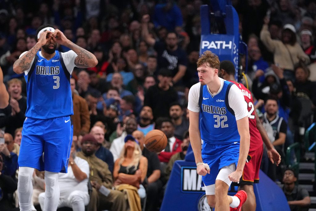 Dallas Mavericks forward Cooper Flagg (32) and forward Anthony Davis (3) react after a basket against the Miami Heat during the second half of an NBA basketball game Wednesday, Dec. 3, 2025, in Dallas. (AP Photo/Julio Cortez)