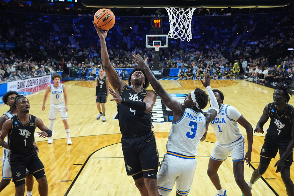 UCF's Jamichael Stillwell (4) goes up for a shot against UCLA's Eric Dailey Jr. (3) during the first half in the first round of the NCAA college basketball tournament, Friday, March 20, 2026, in Philadelphia. (AP Photo/Matt Rourke)