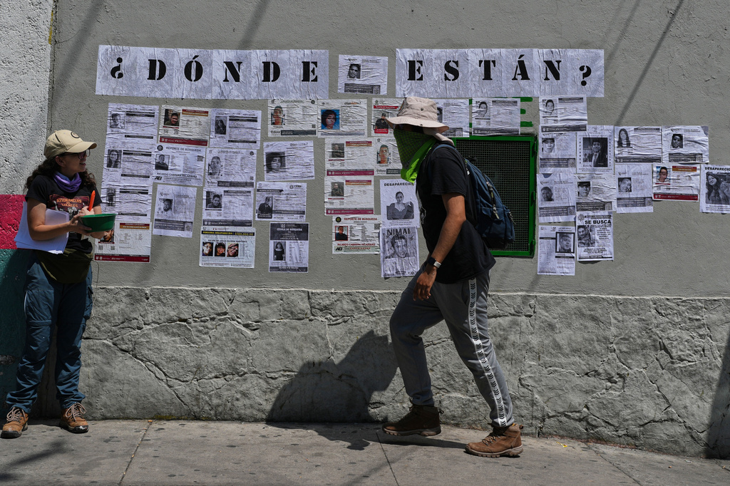 Activists and families of the country's more than 134,000 disappeared people paste missing-person posters in Mexico City, Saturday, May 30, 2026, as Mexico prepares to host the 2026 FIFA World Cup. (AP Photo/Marco Ugarte)