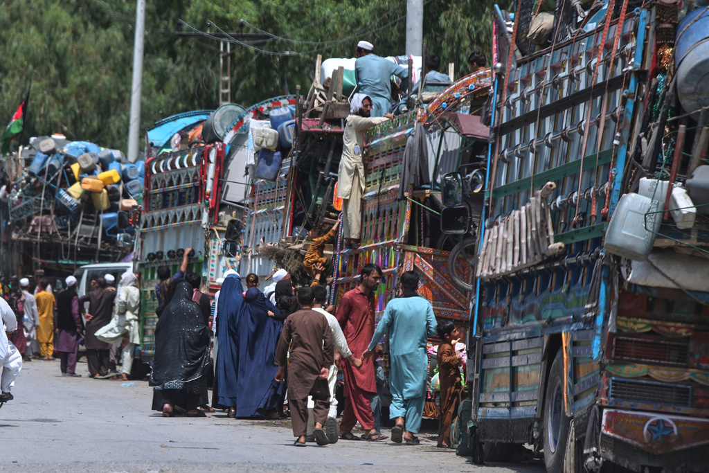 FILE - Afghan refugee families heading back to their homeland, gather next to trucks loaded with their belongings as they wait for documentation at the UNHCR Voluntary Repatriation Centre in Azakhel, Nowshera a district of Pakistan's Khyber Pakhtunkhwa, Monday, Aug. 25, 2025. (AP Photo/Muhammad Sajjad, File)