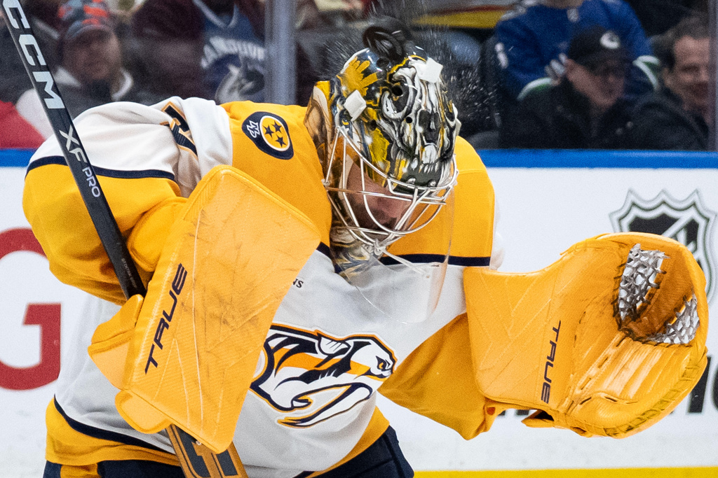 Nashville Predators goaltender Juuse Saros (74) stops the puck against the Vancouver Canucks during the third period of an NHL hockey game in Vancouver, on Thursday, March 12, 2026. (Ethan Cairns/The Canadian Press via AP)