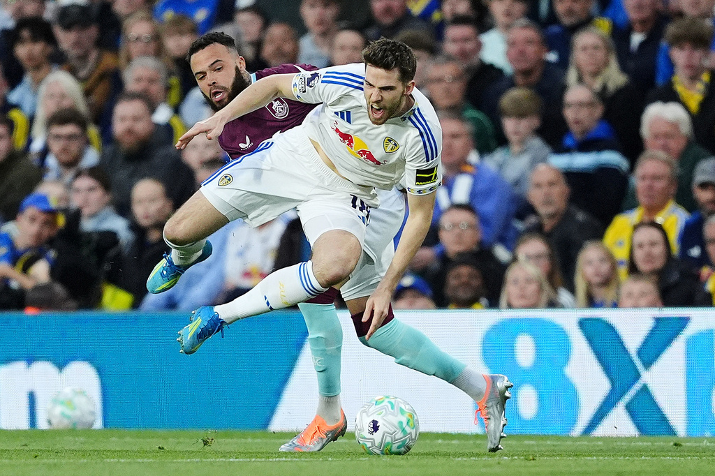 Leeds United's Anton Stach, front, is tackled from behind by Burnley's Quilindschy Hartman during the English Premier League soccer match between Leeds United and Burnley, Friday, May 1, 2026, in Leeds, England. (Martin Rickett/PA via AP)