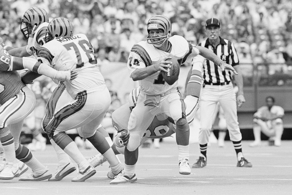 FILE - Cincinnati Bengals quarterback Ken Anderson scrambles out of the pocket and out of the grasp of a Houston Oiler defender during the fourth quarter of an NFL football game in Cincinnati, Sept. 13, 1982. (AP Photo/Ed Reinke, File)