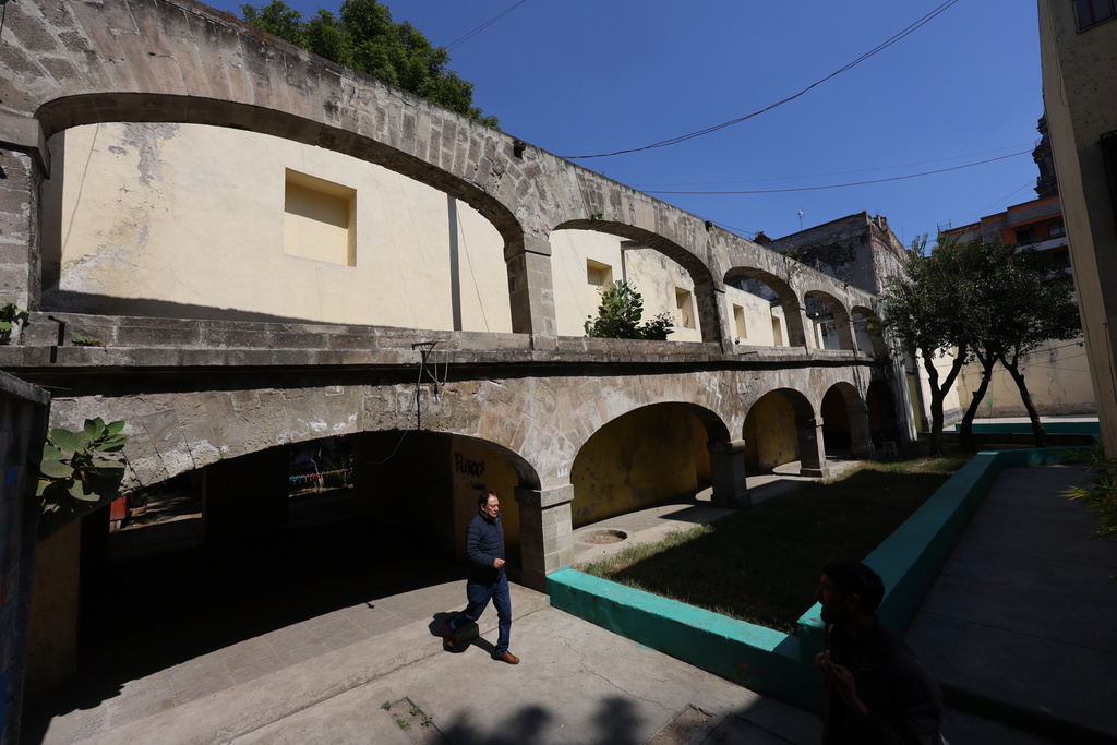 A man walks out of the archway of a cloister that was part of Santo Domingo church, now a residential housing complex in Mexico City, Tuesday, Jan. 27, 2026. (AP Photo/Ginnette Riquelme)