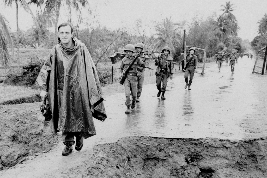 FILE - Associated Press correspondent Peter Arnett, left, marches with Vietnamese troops in Vietnam, Nov. 11, 1965. (AP Photo, File)