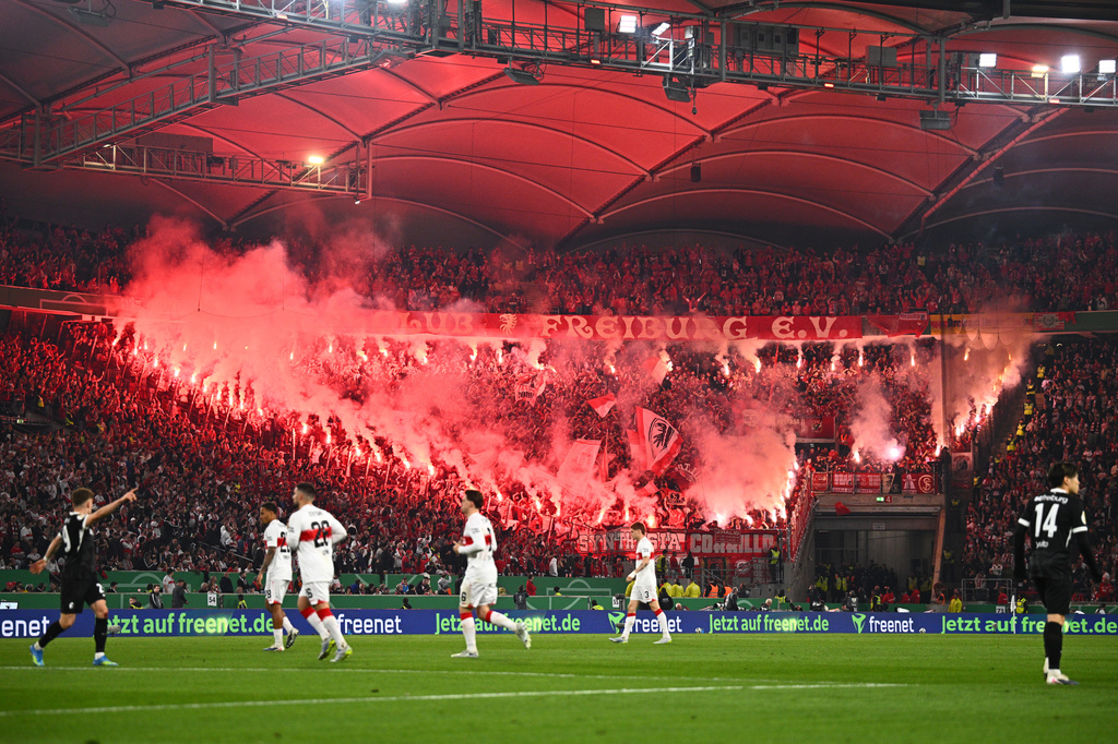 Freiburg fans set off pyrotechnics during a German Cup semifinal soccer match between VfB Stuttgart and SC Freiburg, Thursday, April 23, 2026, in Stuttgart, Germany. (Tom Weller/dpa via AP)