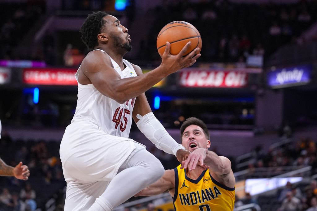 Cleveland Cavaliers guard Donovan Mitchell (45) is fouled by Indiana Pacers guard T.J. McConnell (9) during the first half of an NBA basketball game in Indianapolis, Monday, Dec. 1, 2025. (AP Photo/Michael Conroy)