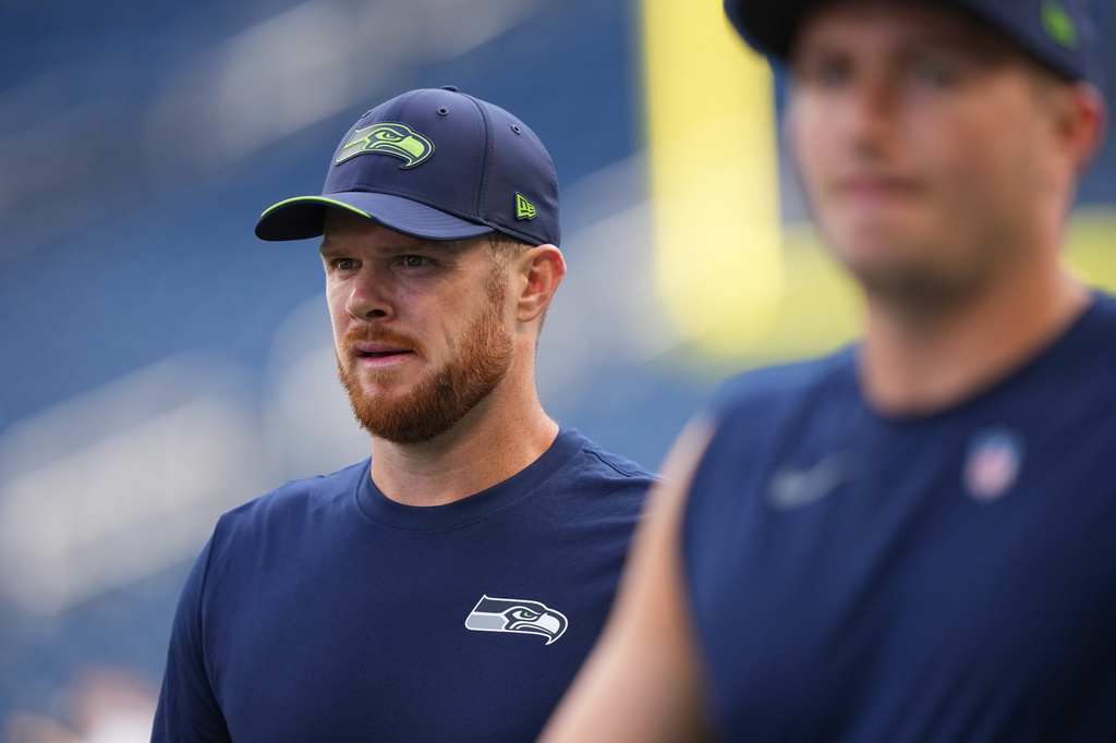 Seattle Seahawks quarterback Sam Darnold, left, walks the field during warmups before an NFL football game against the New England Patriots, Wednesday, Sept. 9, 2026, in Seattle. (AP Photo/Lindsey Wasson)