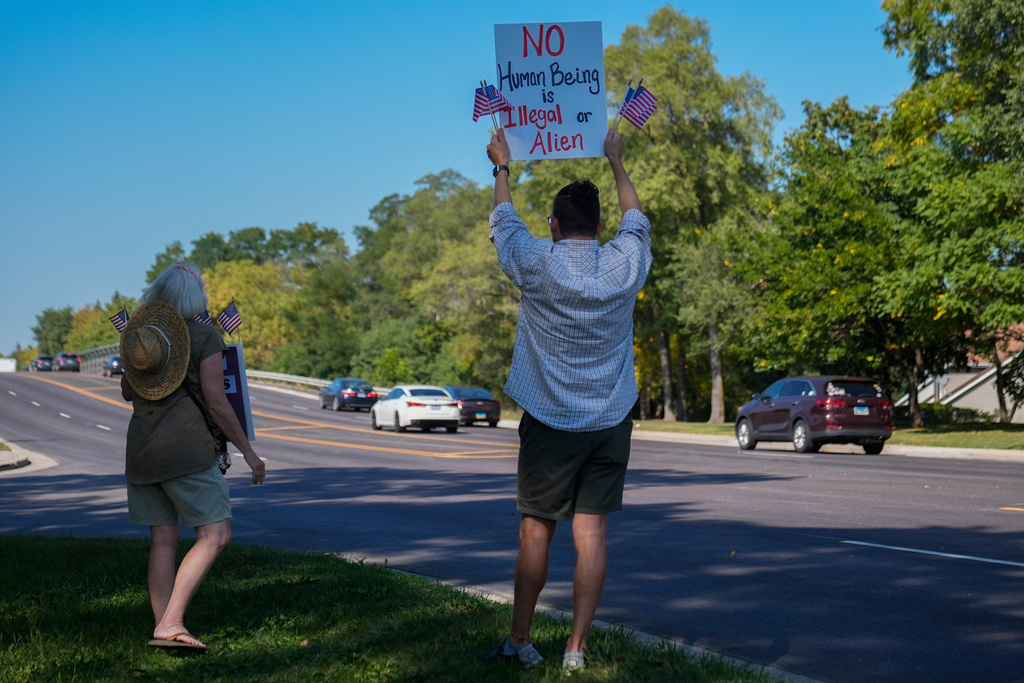 People hold pro-immigrant signs near the Jel Sert Company building, Monday, Sept. 15, 2025, in West Chicago, Ill. (AP Photo/Erin Hooley)