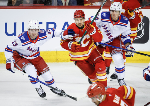 New York Rangers' Alexis Lafreniere, left, and Will Cuylle, right, check Calgary Flames' Mikael Backlund (11) during first-period NHL hockey game action in Calgary, Alberta, Sunday, Oct. 26, 2025. (Jeff McIntosh/The Canadian Press via AP) New York Rangers' Alexis Lafreniere, left, and Will Cuylle, right, check Calgary Flames' Mikael Backlund (11) during first-period NHL hockey game action in Calgary, Alberta, Sunday, Oct. 26, 2025. (Jeff McIntosh/The Canadian Press via AP)