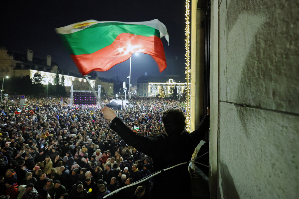 A student waves a Bulgarian flag as a swelling crowd of tens of thousands of Bulgarians filled Sofia's central square, demanding the government's resignation amid rising anger over corruption and contested economic policies, Sofia, Bulgaria, Wednesday, Dec. 10, 2025. (AP Photo/Valentina Petrova)