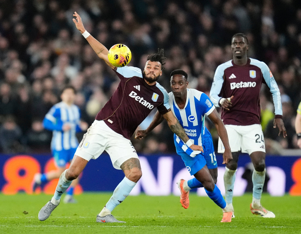 Aston Villa's Tyrone Mings, center left, and Brighton and Hove Albion's Danny Welbeck, center right, vie for the ball during their English Premier League soccer match in Birmingham, England, on Wednesday, Feb. 11, 2026. (Nick Potts/PA via AP)