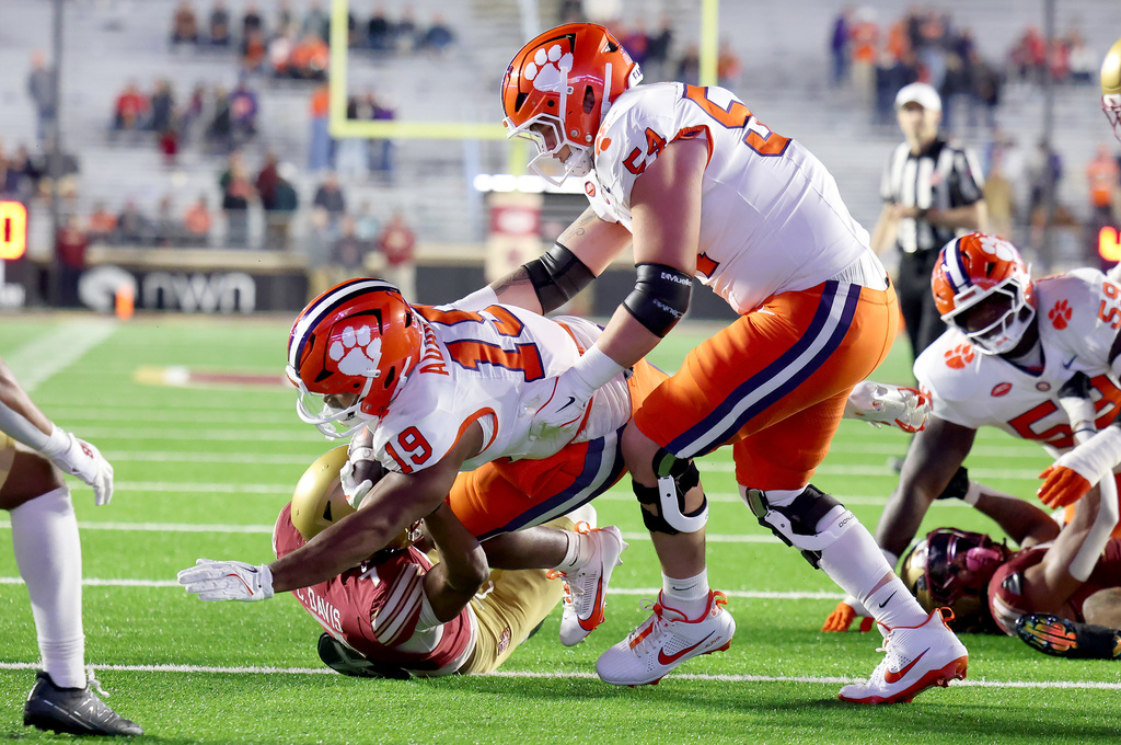 Clemson offensive lineman Ian Reed (54) assists teammate running back Keith Adams Jr. (19) on yardage during the second half of an NCAA college football game against Boston College, Saturday, Oct. 11, 2025 in Boston. (AP Photo/Mark Stockwell)