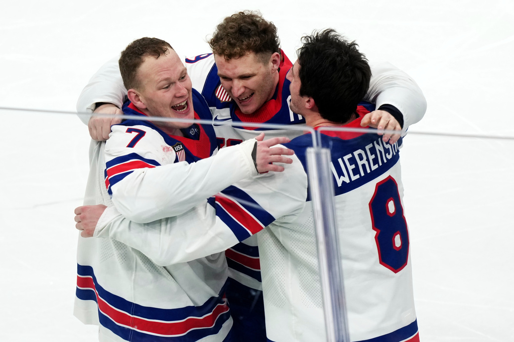 FILE - United States' Brady Tkachuk (7), Matthew Tkachuk, center, and Zach Werenski (8) celebrate after their overtime win against Canada in the men's ice hockey gold medal game at the 2026 Winter Olympics in Milan on Feb. 22, 2026. (AP Photo/Carolyn Kaster, File)
