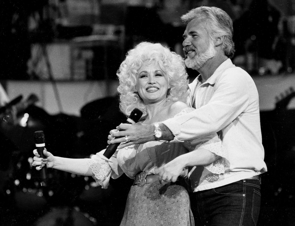 FILE - Dolly Parton, left, and Kenny Rogers rehearse a song for their appearance on the TV show "Live... And in Person" in Los Angeles on Sept. 27, 1983. (AP Photo/Doug Pizac, File)
