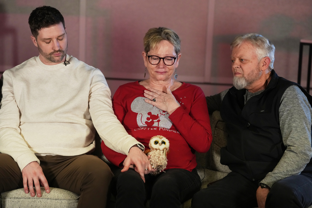 From left, Brent Ganger consoles his mother, Donna, center, and father, Tim Ganger, during an interview in Denver, on Friday, Feb. 27, 2026. (AP Photo/David Zalubowski)