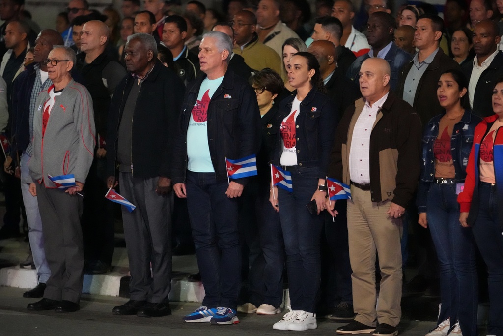 Cuba's President Miguel Diaz Canel, center, listens to the national anthem before the start of a march to mark the 173rd anniversary of the birth of national independence hero Jose Marti, in Havana, Tuesday, Jan. 27, 2026. (AP Photo/Ramon Espinosa)