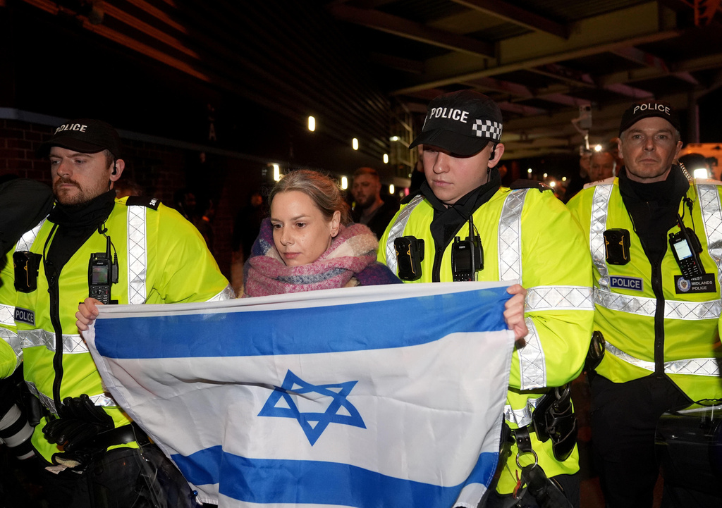 A women named Emily carrying an Israel flag is moved away by police officers from pro Palestine campaigners, who are protesting outside Villa Park, ahead of the Europa League soccer match between Aston Villa and Maccabi Tel Aviv in Birmingham, England, Thursday, Nov. 6, 2025. (Joe Giddens/PA via AP)