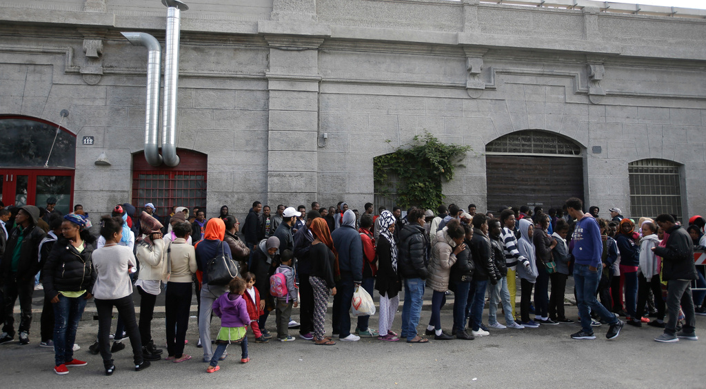 FILE - Migrants queue to enter a refectory in Milan, Italy, on Oct. 21, 2016. (AP Photo/Luca Bruno, File)