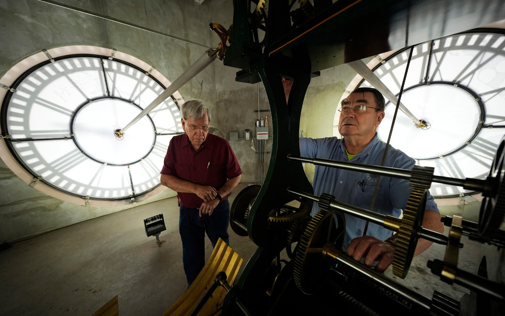 FILE- Chuck Roeser, right, and Don Bugh set the time forward on the historic clock tower atop the Dallas County Courthouse, March 7, 2024, in Dallas. The mechanical clock built in 1890 requires hand lubrication and reseting twice a year with daylight saving time. (AP Photo/LM Otero, File)
