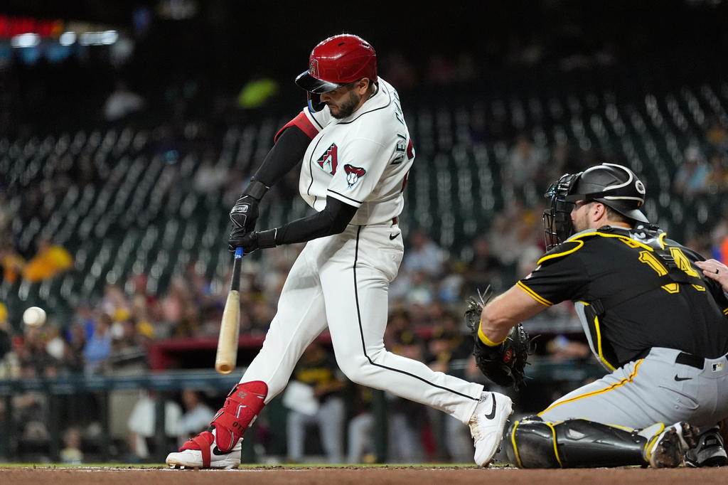 Arizona Diamondbacks' Adrian Del Castillo, left, connects for a run-scoring single as Pittsburgh Pirates catcher Joey Bart (14) reaches for the ball during the first inning of a baseball game, Thursday, May 7, 2026, in Phoenix. (AP Photo/Ross D. Franklin)