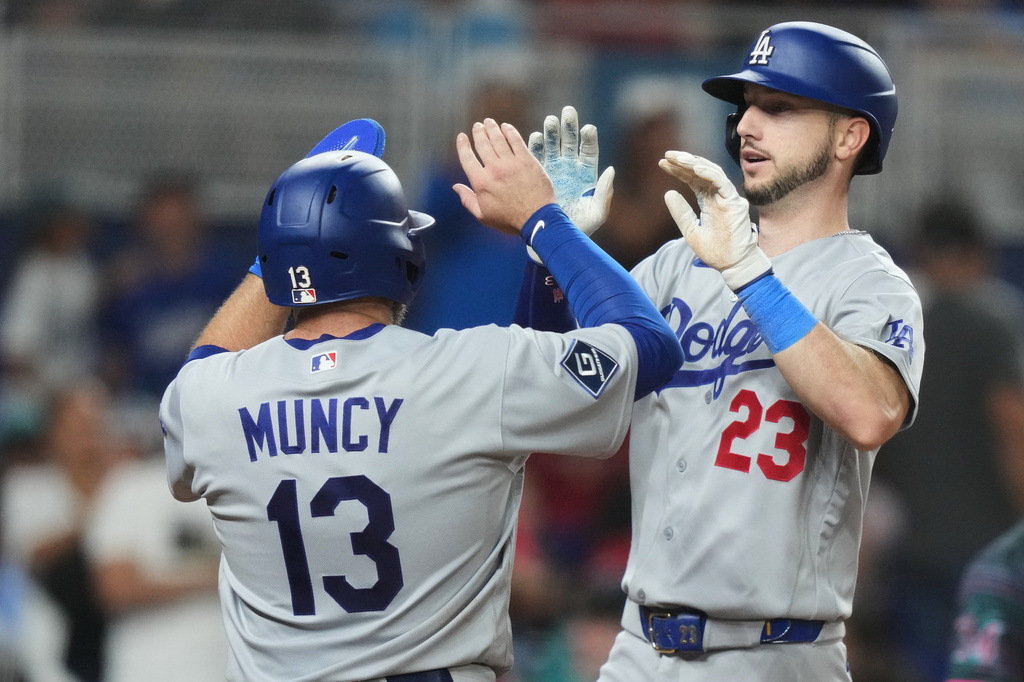 Los Angeles Dodgers' Kyle Tucker (23) is met at the plate by Max Muncy (13) after hitting a grand slam during the seventh inning of a baseball game against the Miami Marlins, Friday, Sept. 11, 2026, in Miami. (AP Photo/Lynne Sladky)