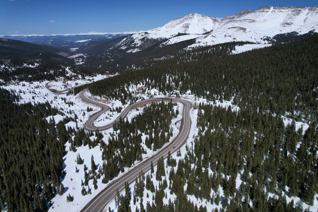 FILE - A road winds through the snow-covered Rocky Mountains at Hoosier Pass on April 18, 2022, near Blue River, Colo. (AP Photo/Brittany Peterson, File)