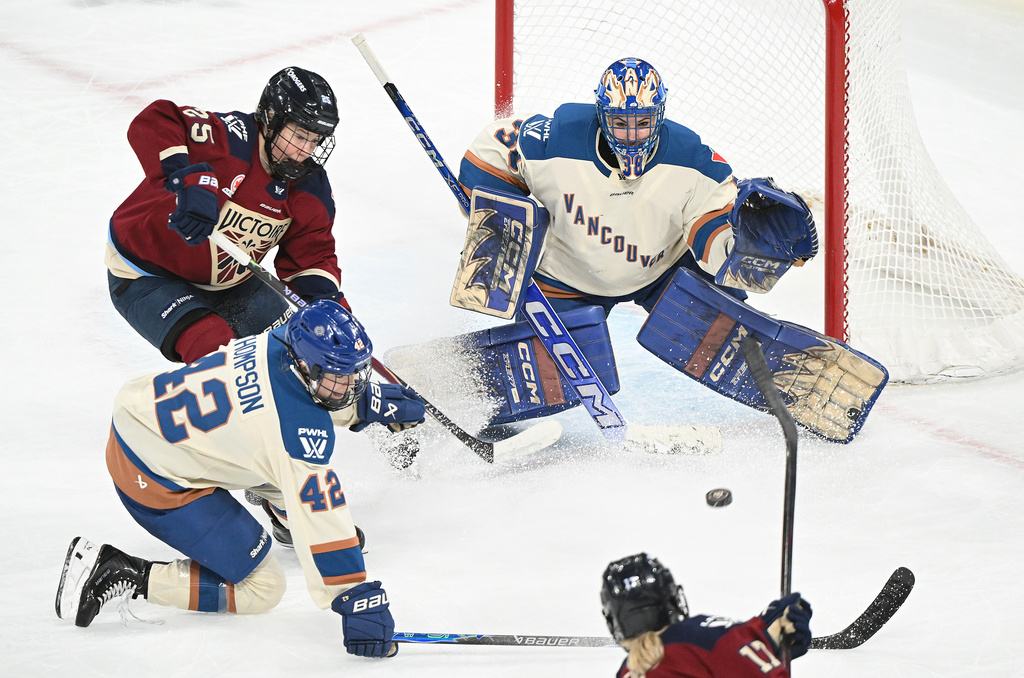 Montreal Victoire's Dara Greig (17) takes a shot on Vancouver Goldeneyes goaltender Emerance Maschmeyer (38) as Goldeneyes' Claire Thompson (42) and Victoire's Lina Ljungblom (25) look for a rebound during second period PWHL hockey game in Laval, Que., Wednesday, April 1, 2026. (Graham Hughes/The Canadian Press via AP)