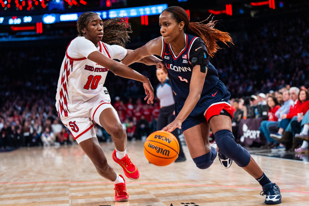 UConn guard Blanca Quinonez (4), guarded by St. John's guard Brooke Moore (10), heads toward the basket during the first half of an NCAA college basketball game, Sunday, March 1, 2026, in New York. (AP Photo/Angelina Katsanis)