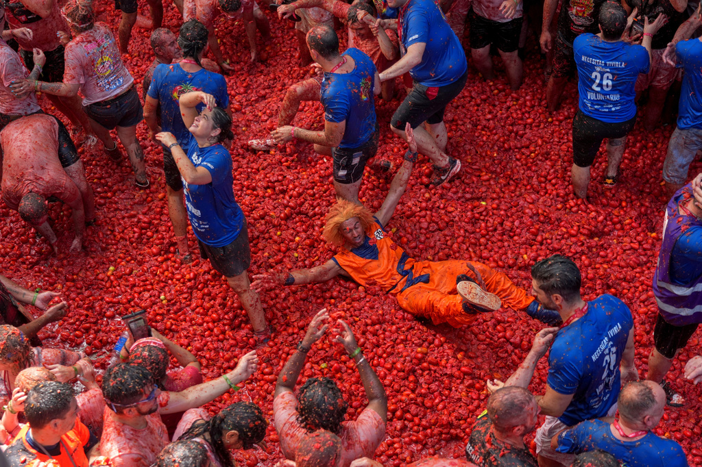 Revelers throw tomatoes at each other during the annual "Tomatina" tomato fight fiesta, in the village of Bunol near Valencia, Spain, Wednesday, Aug. 26, 2026. (AP Photo/Alberto Saiz)