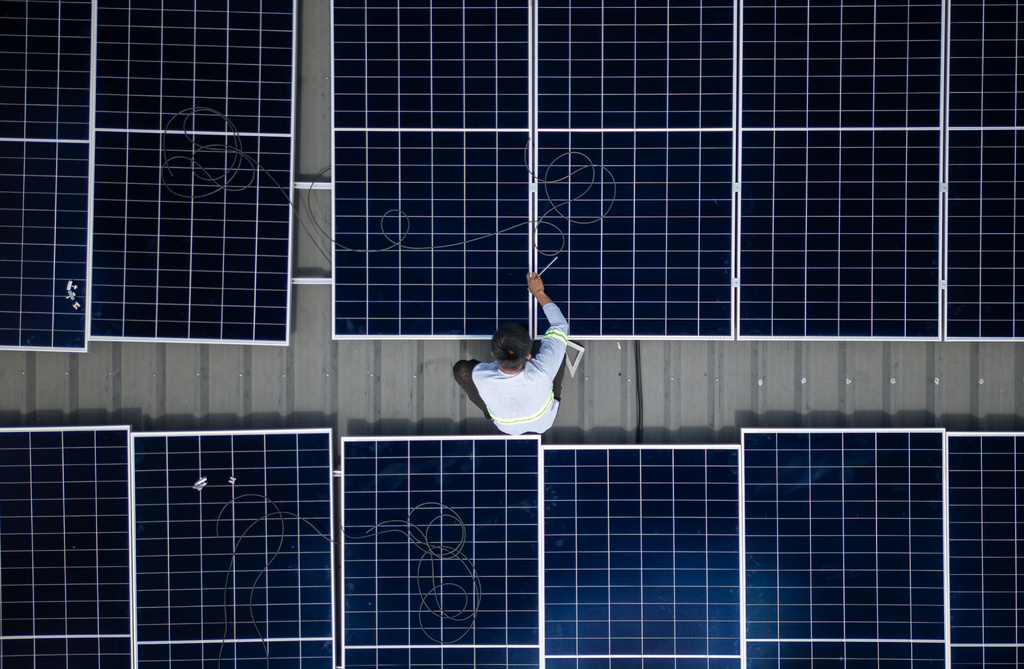 A solar installer secures a solar panel onto the roof of a home in Manila, Philippines, on May 1, 2026. (AP Photo/Anton L. Delgado)