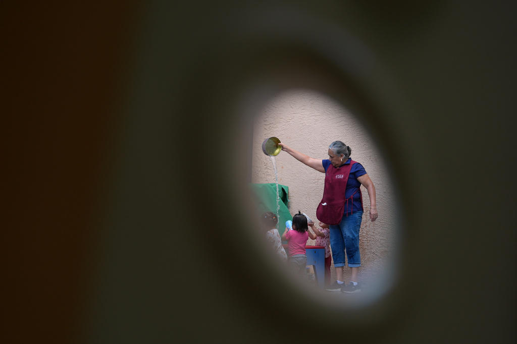A teacher plays with children at a water table, at a Head Start preschool in Immokalee, Fla., Thursday, Sept. 10, 2026. (AP Photo/Rebecca Blackwell)