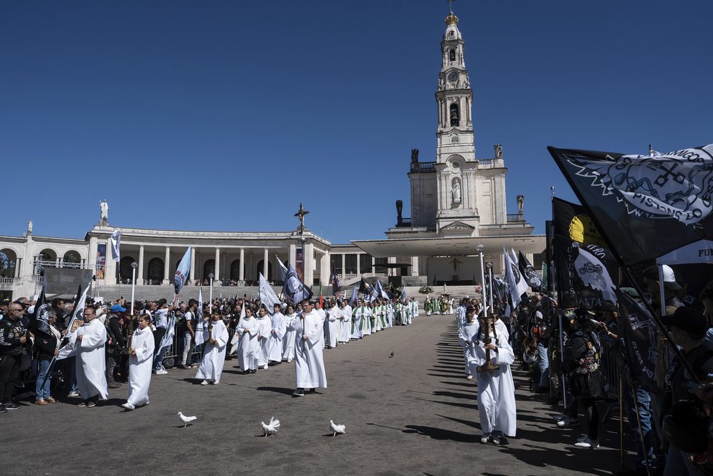 A procession move through the crowd at the end of mass during the 10th Pilgrimage of the Blessing of Helmets that draws tens of thousands, at the Roman Catholic holy shrine of Fatima, in Fatima, Portugal, Sunday, Sept. 21, 2025. (AP Photo/Ana Brigida)