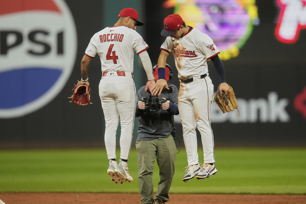 Cleveland Guardians second baseman Brayan Rocchio (4) and left fielder Steven Kwan, right, celebrate after the Guardians defeated the Tampa Bay Rays in a baseball game in Cleveland, Tuesday, Aug. 26, 2025. (AP Photo/Sue Ogrocki)