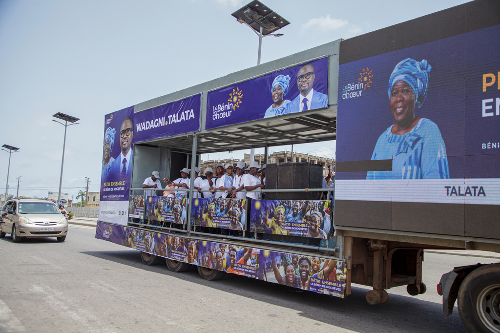 People ride in an election caravan displaying photos of presidential candidate Romuald Wadagni and his running mate, Mariam Chabi Talata, at a campaign rally in Cotonou, Benin, Friday, April 10, 2026. (AP Photo/Abadjaye Justin Sodogandji)