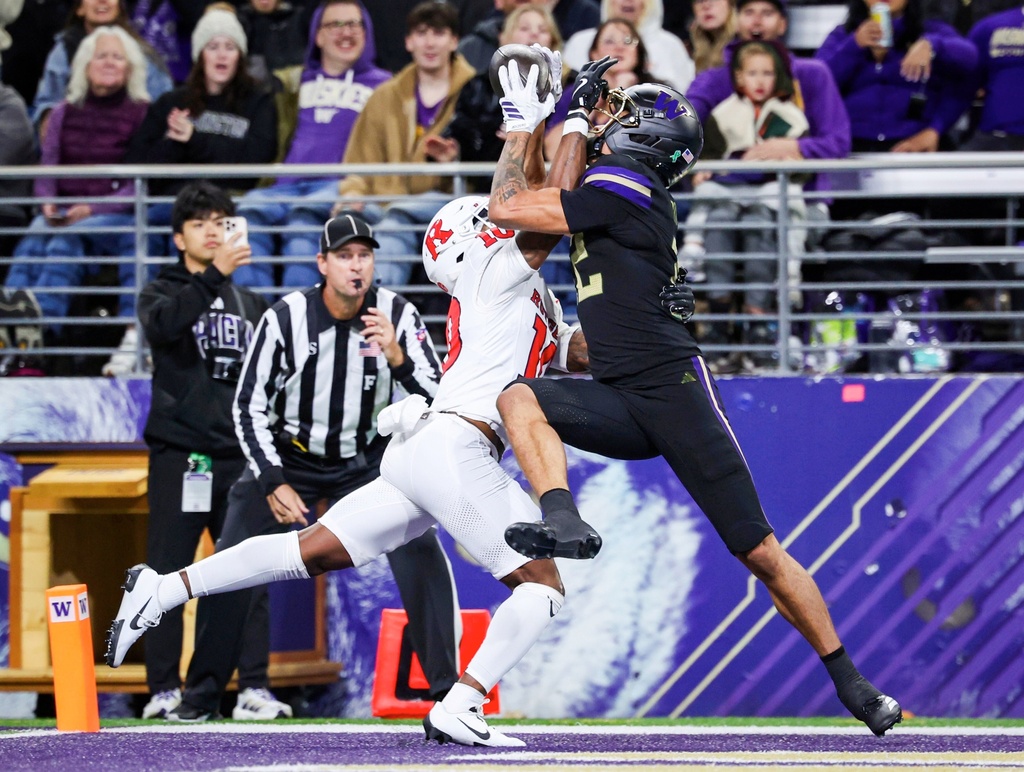 Washington wide receiver Denzel Boston, right, catches a touchdown pass over Rutgers defensive back Jacobie Henderson, left, in the second quarter of an NCAA college football game Friday, Oct. 10, 2025, in Seattle. (Nick Wagner/The Seattle Times via AP)
