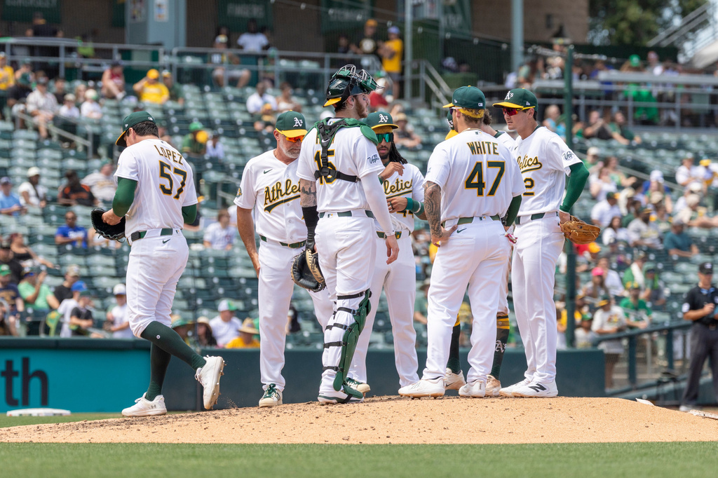 Athletics pitcher Jacob Lopez, left, leaves the mound during the fifth inning of a baseball game against the Washington Nationals, Sunday, July 19, 2026, in West Sacramento, Calif. (AP Photo/Sara Nevis)