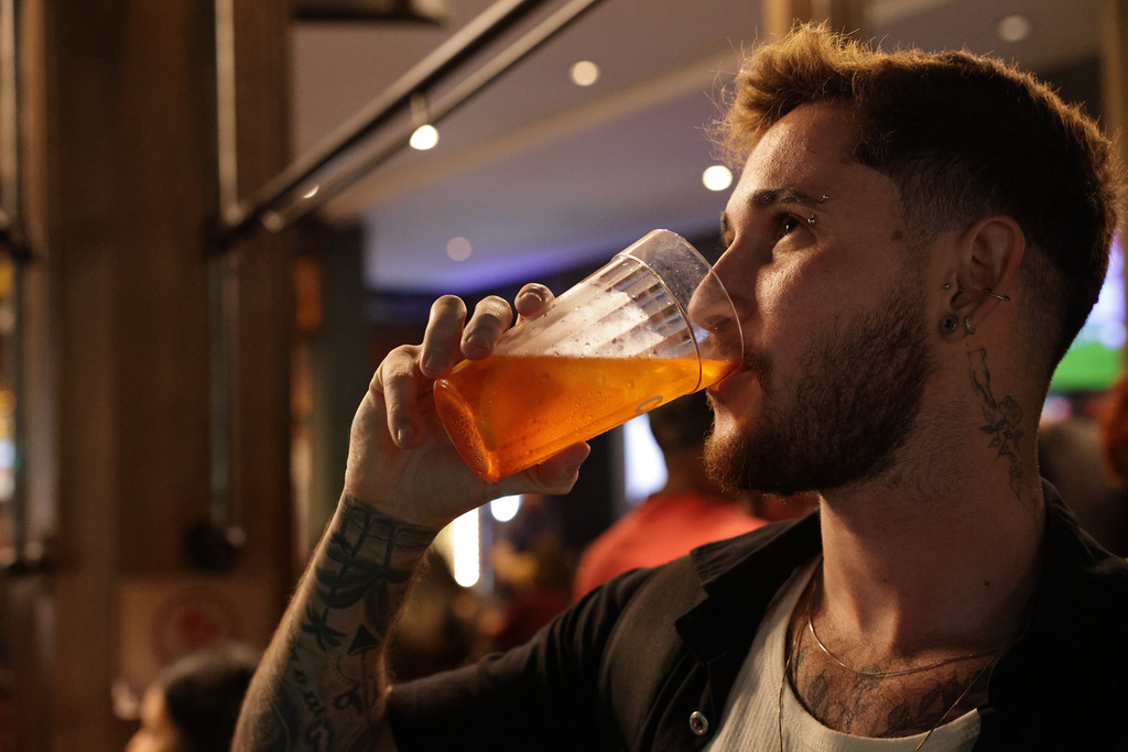 Gustavo Candido drinks liquor at a bar in Sao Paulo, Friday, Oct. 3, 2025. (AP Photo/Ettore Chiereguini)