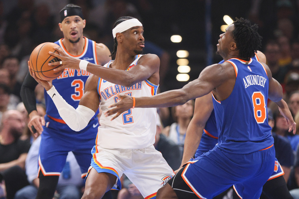 Oklahoma City Thunder guard Shai Gilgeous-Alexander (2) keeps the ball away from New York Knicks forward Og Anunoby (8) and guard Josh Hart (3) during the first half of an NBA basketball game Sunday, March 29, 2026, in Oklahoma City. (AP Photo/Nate Billings)