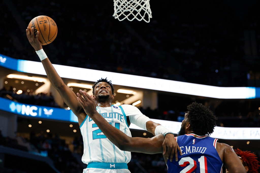 Charlotte Hornets forward Brandon Miller, left, drives to the basket against Philadelphia 76ers center Joel Embiid during the first half of an NBA basketball game in Charlotte, N.C., Saturday, March 28, 2026. (AP Photo/Nell Redmond)
