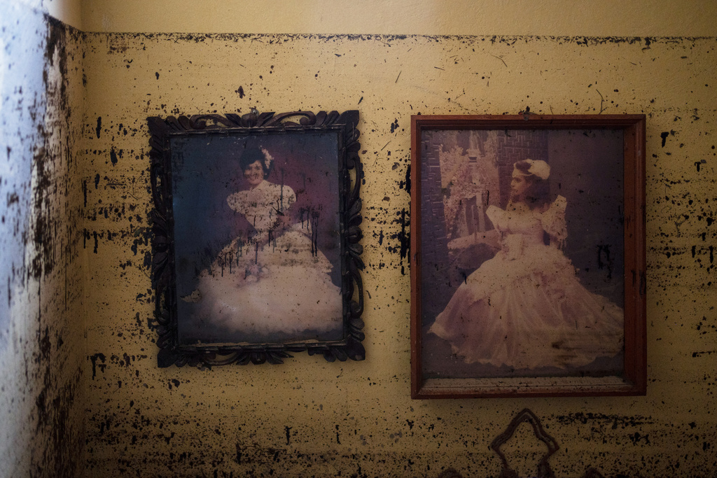 Portraits hang on the Ramirez family's houses wall in Poza Rica, Veracruz state, Mexico, Monday, Oct. 13, 2025, after torrential rains. (AP Photo/Felix Marquez)