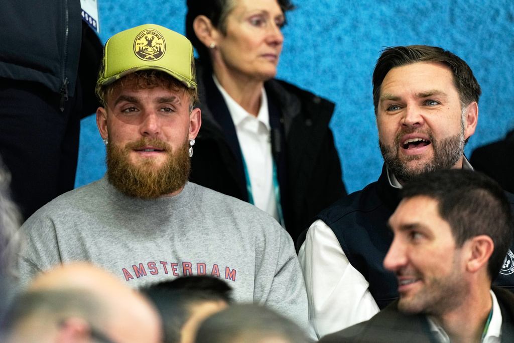 Jake Paul, left, and Vice President JD Vance attend a preliminary round match of women's ice hockey between the United States and Finland at the 2026 Winter Olympics, in Milan, Italy, Saturday, Feb. 7, 2026. (AP Photo/Petr David Josek)
