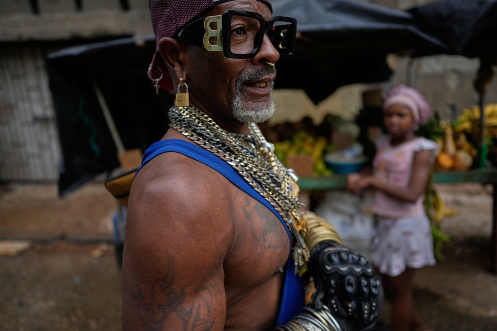 FILE - A man wearing necklaces and a padlock as an earring walks through Havana, Cuba, Jan. 12, 2026. (AP Photo/Ramón Espinosa, File)
