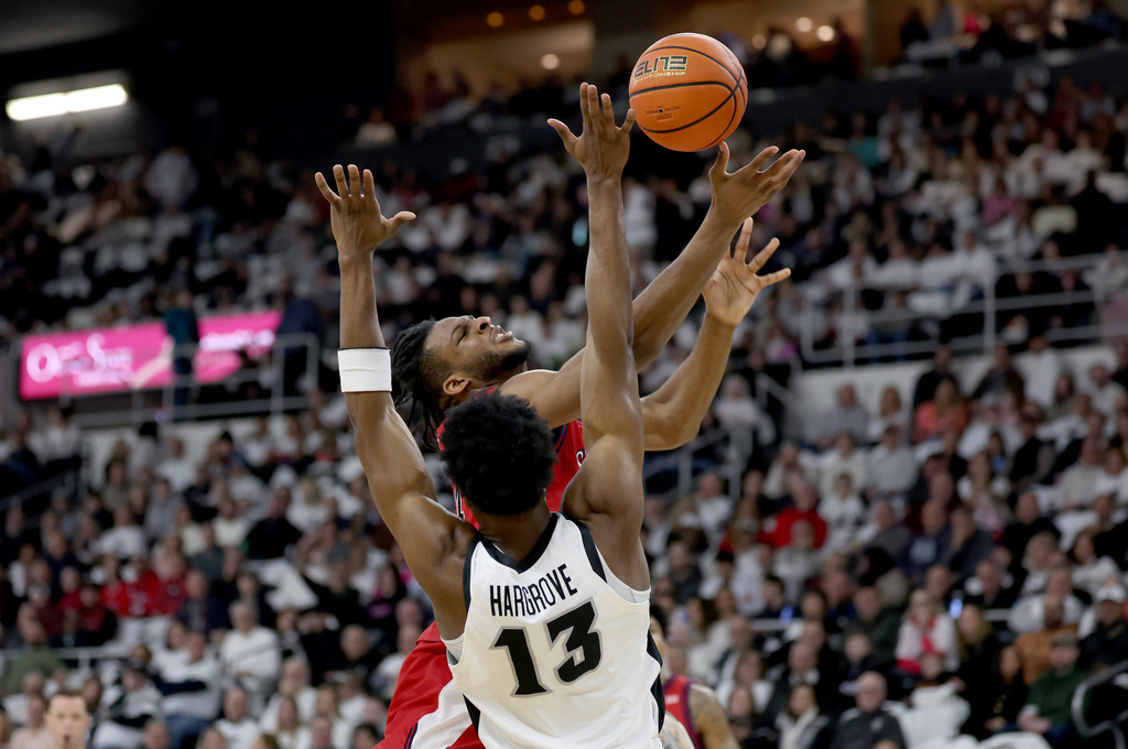Providence forward Cole Hargrove (13) fouls St. John's forward Zuby Ejiofor under the net during the first half of an NCAA college basketball game, Saturday, Feb. 14, 2026, in Providence, R.I. (AP Photo/Mark Stockwell)